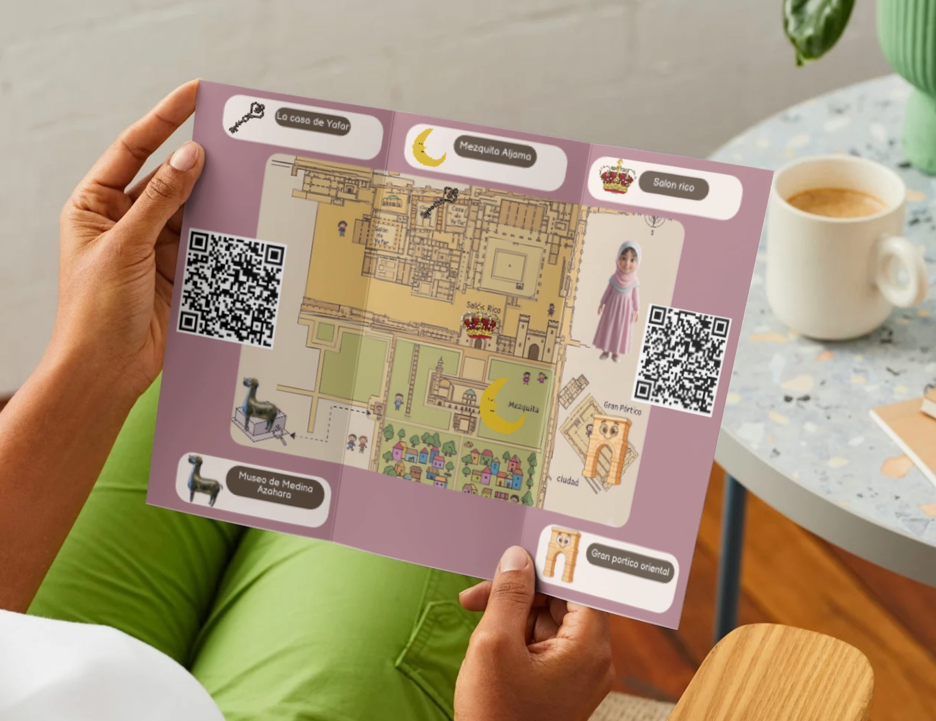 Tríptico ilustrado de Medina Azahara con mapa y códigos QR, sostenido en la mano